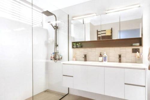 布里斯班Best Value With City View Sleeps 7的白色的浴室设有水槽和淋浴。