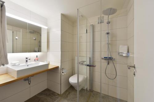 伦克斯特恩酒店的带淋浴、卫生间和盥洗盆的浴室