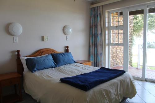 马盖特Anguna Holiday Flats的一间卧室配有一张带蓝色枕头的床和一扇窗户。