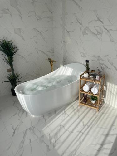 尼兹瓦Al ATLAL apartment的浴室设有白色浴缸,拥有大理石墙壁。