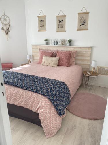 利雪L’appart的一间卧室配有一张大床,铺有粉色和蓝色的床单。