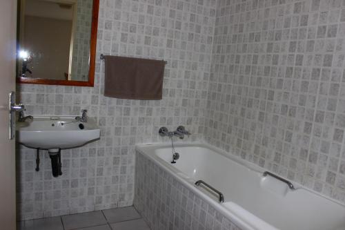 马盖特Anguna Holiday Flats的浴室配有盥洗盆、浴缸和盥洗盆