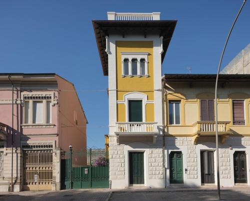维亚雷焦Villa Giulia BnB的城市街道上的一座黄色和白色的建筑