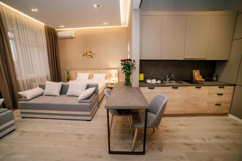 特鲁斯卡韦茨Apart-Hotel CARDINAL的厨房以及带沙发和桌子的客厅。