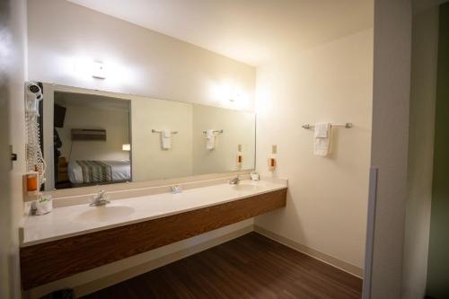 西黄石Mountain Vista Hotel的一间带两个盥洗盆和大镜子的浴室