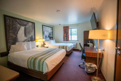 西黄石Mountain Vista Hotel的酒店客房配有两张床和一张书桌
