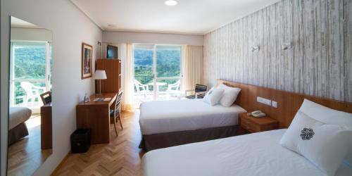 阿尔诺亚ARNOIA CALDARIA HOTEL Y BALNEARIO的酒店客房设有两张床和一个阳台。