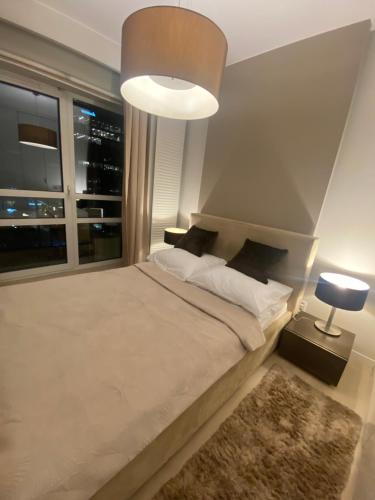 华沙Platinum Towers great view balcony 1 bedroom的一间卧室设有一张大床和大窗户