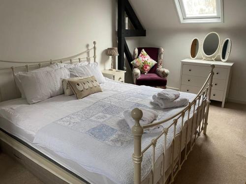 伯恩茅斯The Old Barn Throop. Spacious Barn conversion.的卧室配有一张带白色床单和枕头的大床。