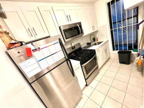 威霍肯Nice 2 bedrooms apartament 10 minutes to Times Square的厨房配有不锈钢冰箱和白色橱柜