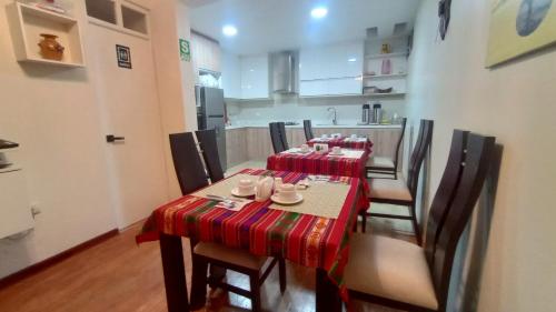 普诺MADA Guest House Puno "Hospedaje"的一间带桌椅和红色桌布的用餐室