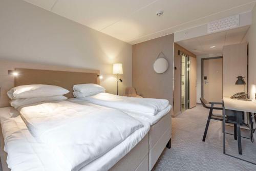 摩城斯堪梅耶花园酒店的卧室配有一张白色大床和一张书桌