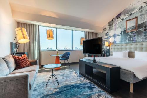 哥德堡滨河丽笙酒店的酒店客房设有一张大床和一张沙发。