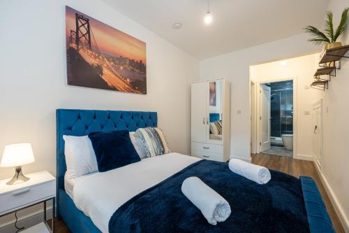 曼彻斯特Stunning 2 Bedroom Apartment in Chorlton的一间卧室配有蓝色的床和白色枕头