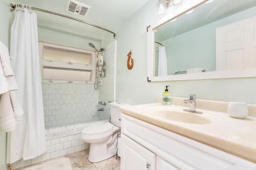 檀香山Tranquil Marina Front Pool House Resort的白色的浴室设有水槽和卫生间。