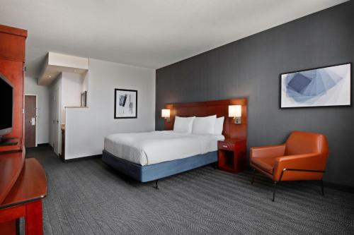 堪萨斯城堪萨斯城布赖尔克利夫万怡酒店的配有一张床和一把椅子的酒店客房