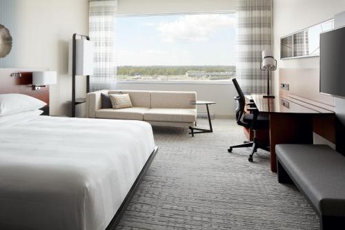 多瓦尔Marriott Montreal Airport In-Terminal Hotel的配有一张床和一张书桌的酒店客房