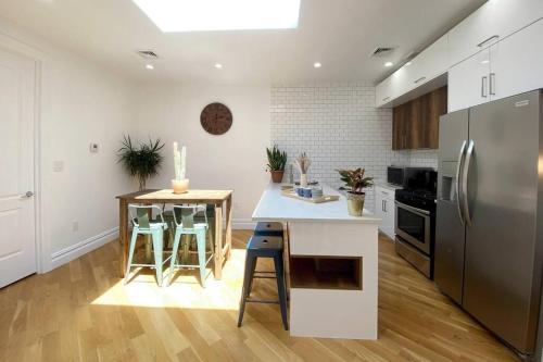 布鲁克林Cozy Bedroom - Shared Kitchen & Living room - Brooklyn Townhouse - 25min Manhattan的厨房配有冰箱和带凳子的台面