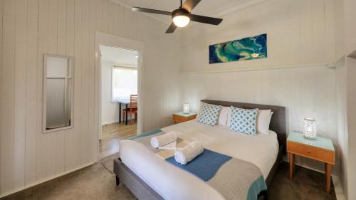 史丹霍普Creekview Cottage - 70 Lock Street的一间卧室配有一张床和吊扇