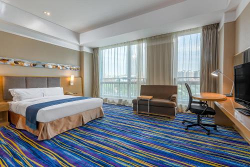 天津天津和平智选假日酒店的酒店客房设有一张床、一张书桌和一台电视机。