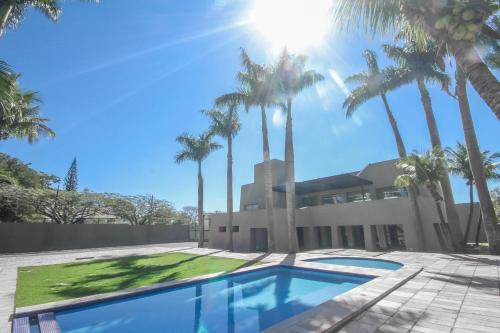 多拉杜斯盖尔斯公园酒店的棕榈树和游泳池的房子