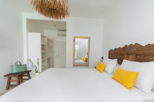 乌鲁瓦图The Room Padang-Padang的白色卧室配有一张带黄色枕头的大床