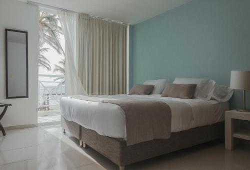 圣安德烈斯Hotel San Luis Beach House的一间卧室设有一张大床和一个大窗户