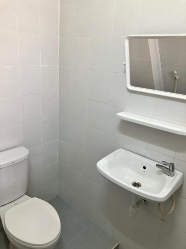 玛哈沙拉堪Sataya Apartment的白色的浴室设有卫生间和水槽。