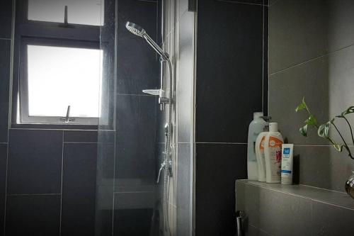 普崇mozhouze studio @ 8 Kinrara Service Apartment的带淋浴的浴室和玻璃门