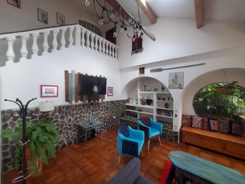 圣马科斯拉拉古纳El Castillo en el Lago Atitlán的客厅配有2把蓝色椅子和电视