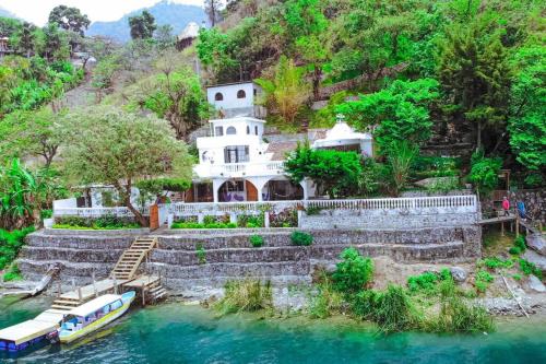 圣马科斯拉拉古纳El Castillo en el Lago Atitlán的河上的房子,水里有船