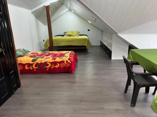 基多Casa de Campo Guayllabamba的阁楼卧室配有两张床和一张桌子