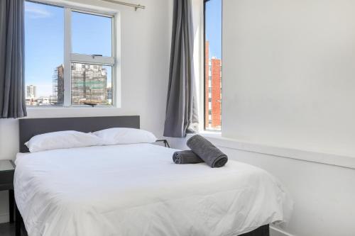 开普敦Inn & Out Express Sea Point的卧室配有白色的床和两个枕头