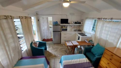 阿瓦鲁阿Are Tamareni 2BR Beach Cottage or River Studio的一间厨房,内设蓝色的椅子和桌子