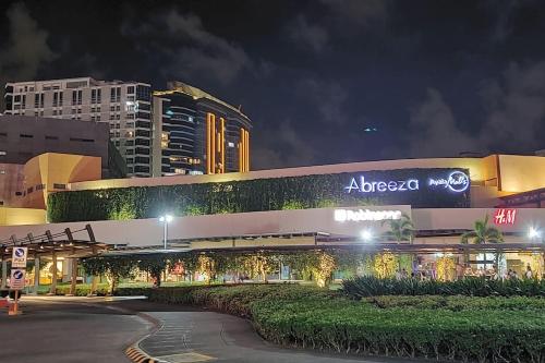 达沃市Davao City Serenity on Seventeenth One-Bedroom Condo beside Shopping Malls with Seaview and City view的一座建筑物,晚上在建筑物的一侧有标志