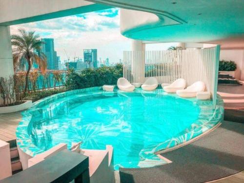 马尼拉Aveline Suites Modern Amenity View ACQUA Private Residences near Rockwell Makati的一座带白色椅子的大型游泳池