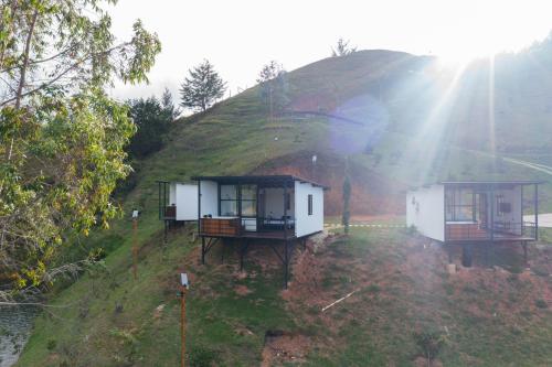 El PeñolLaze Lake Guatape的山上两座小房子,阳光灿烂