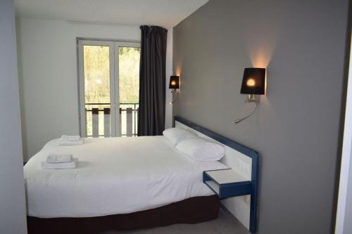 阿林萨尔HOTEL VICTORIA的一间卧室配有一张带白色床单的床和一扇窗户。