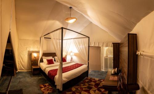 SomvārpetRedberry's Luxury Stay的一间帐篷内带天蓬床的卧室