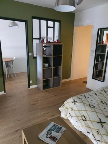 普瓦捷Charmant studio proche chu campus commerces的一间卧室设有绿色的墙壁、一张床和一张桌子