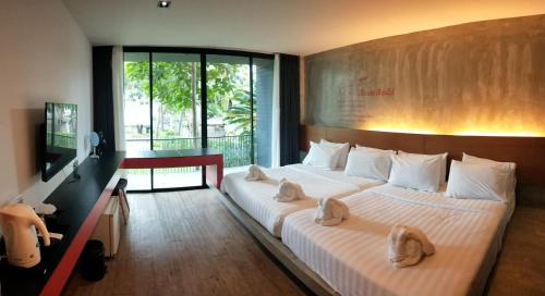 沙美岛Stellars Samed Resort的一间卧室配有一张大床和毛巾