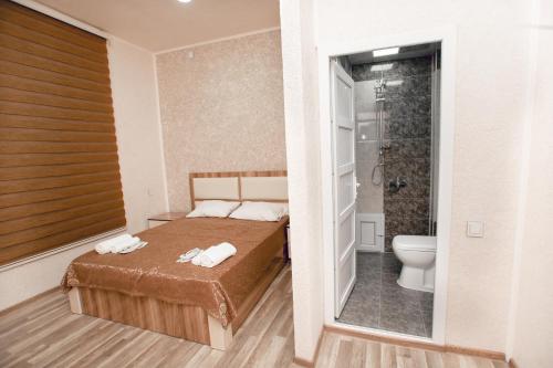 甘贾NM Butik Hotel的一间卧室设有一张床、淋浴和卫生间