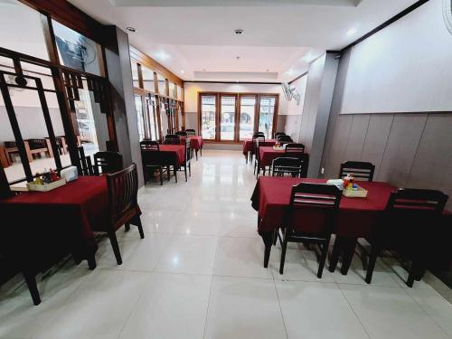 万象Sinakhone Vientiane Hotel的餐厅内带红色桌椅的用餐室