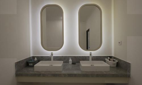 沙努尔Aiwan Hostel & Luggage storage的浴室设有2个水槽和2面镜子