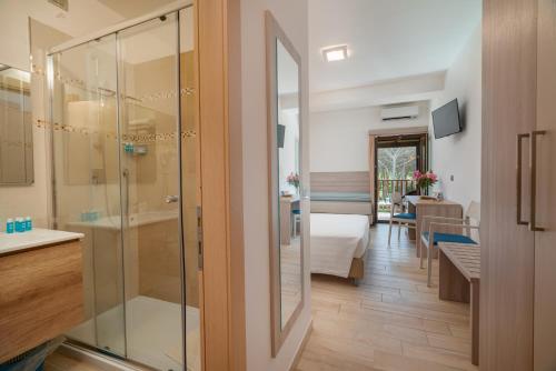 康特港Hotel Portoconte的浴室设有玻璃门,可通往卧室