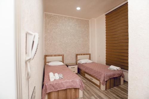甘贾NM Butik Hotel的一间客房内配有两张床的房间