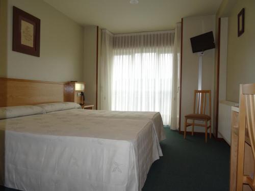 圣地亚哥－德孔波斯特拉阿克拉雷酒店的酒店客房设有床和窗户。
