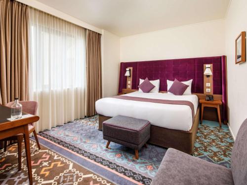 伦敦伦敦桥美居酒店的酒店客房设有一张大床和一张沙发。