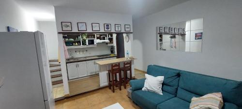 蓬塔穆赫雷斯Ocean’s Eleven Punta Mujeres的一间带蓝色沙发的客厅和一间厨房