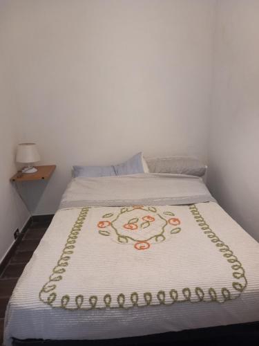 泰拉奇纳Casa tiziana的一张带白色毯子的床,上面有花